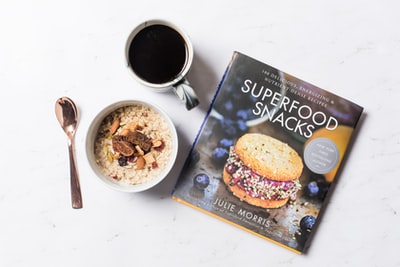 咖啡、超级食品小吃杂志和一碗谷类食品的平面摄影